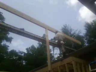 Carpenter setting a ridge beam over a new addition frame — Ice Dam Removal by Roofing Brothers in Robertsdale