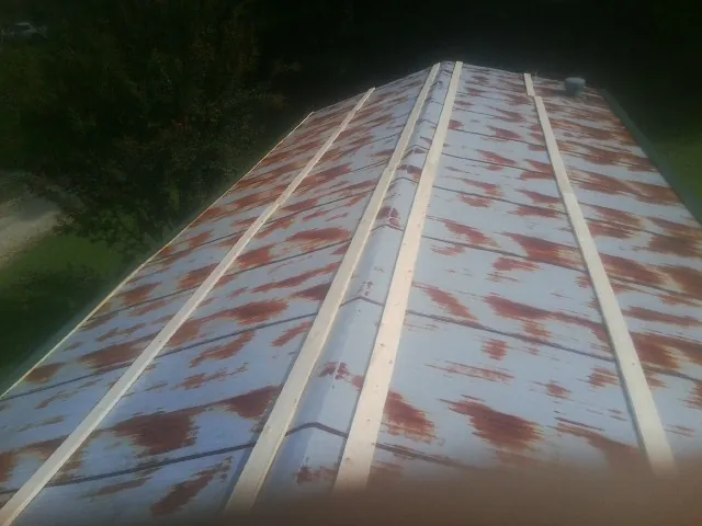 Rusted metal roof panels with new wood purlins before replacement — Storm Damage Roof Repair in Robertsdale by Roofing Brothers