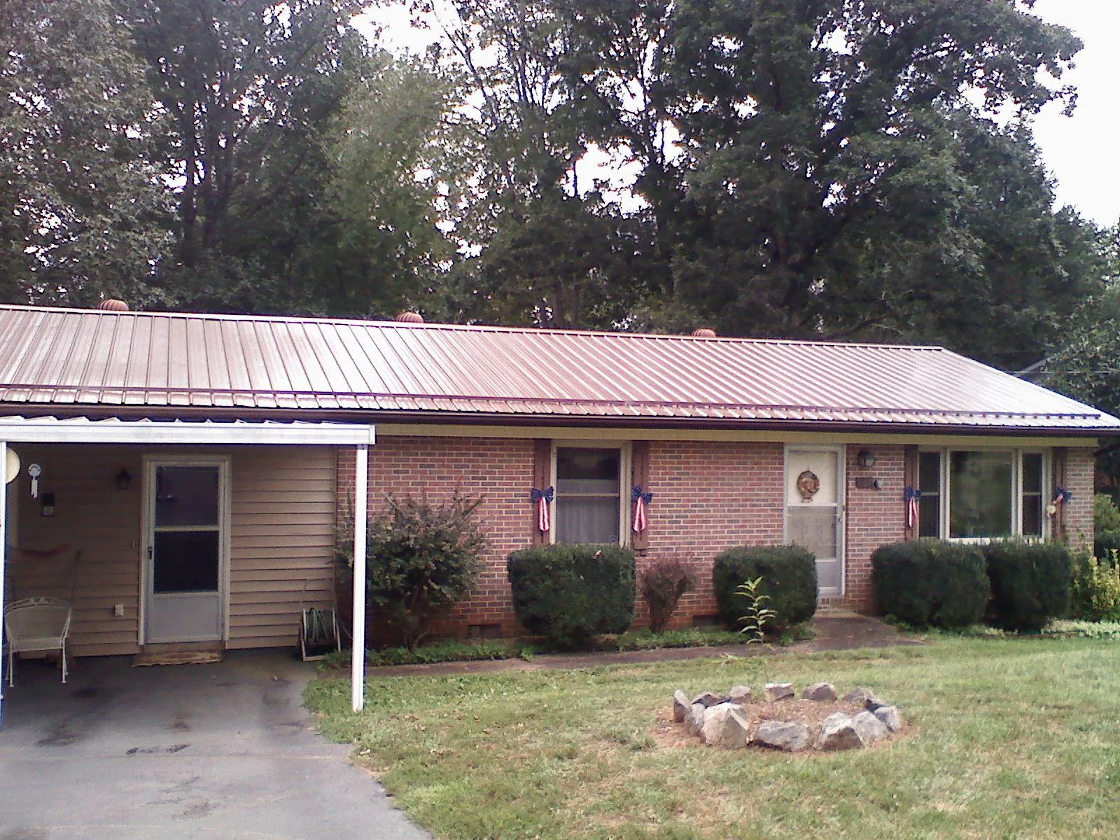 Bronze metal roof and carport on a brick ranch home — Roof Repair work by our crew in Robertsdale