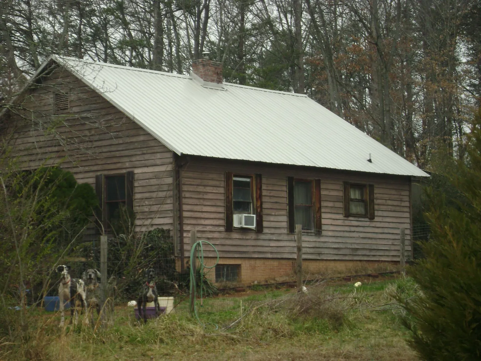 White metal roof on an old wood sided farmhouse, from a Metal Roof Installation job in Robertsdale